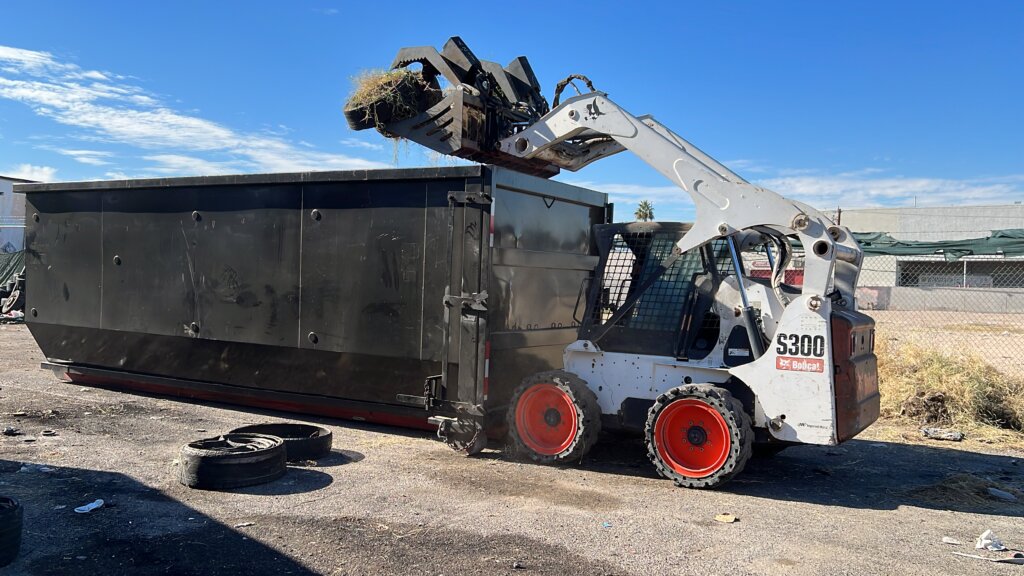 Skid steer loading a dumpster