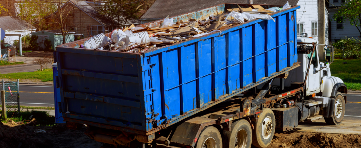 Junk removal truck taking away debris from a home