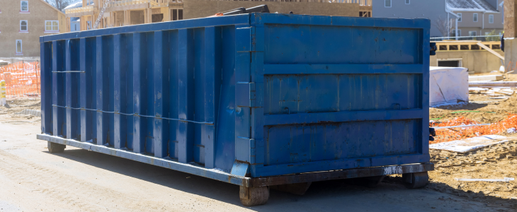 Dumpster sitting in front of a construction project