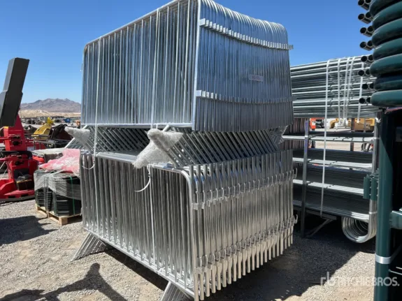 Stacked metal barricades on a construction site under a clear sky