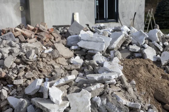 Construction waste from the revitalization of an old house. Pieces of polystyrene and construction rubble are in front of the house for removal