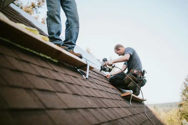 A roofer and crew work on putting in new roofing shingles. Small local business serving local families in Washington State.