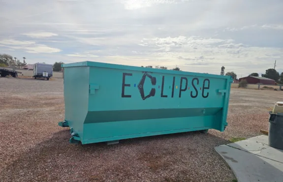 A large turquoise dumpster with the word 