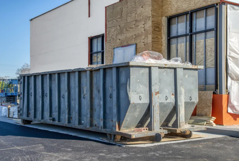 A big, heavy-duty dumpster next to a new fast food restaurant under construction